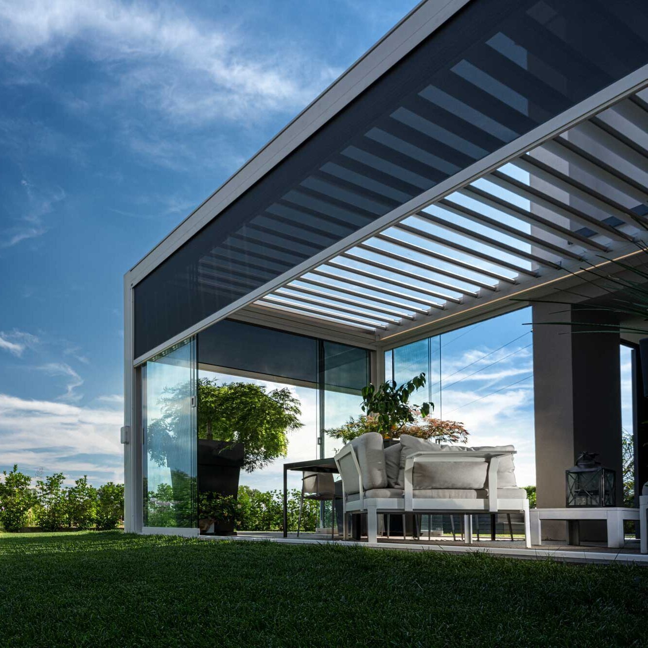 Pergola bicoclimatique acec des stores zip pour créer une veritable pièces et protéger du vent